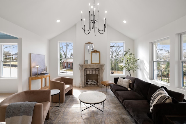 living room featuring an inviting chandelier, lofted ceiling, and a fireplace