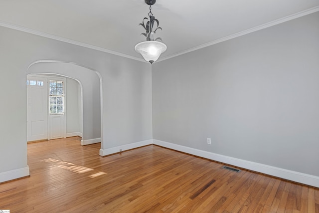 empty room featuring ornamental molding and light wood-type flooring