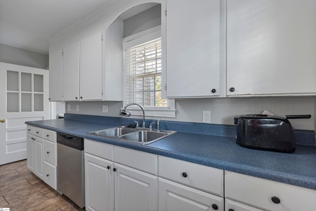 kitchen featuring dishwasher, sink, and white cabinets