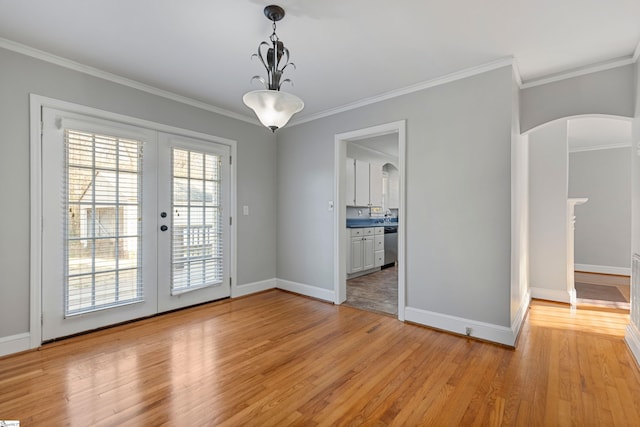 unfurnished dining area featuring french doors, ornamental molding, and light hardwood / wood-style flooring