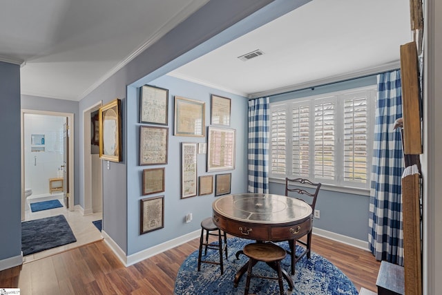 dining area featuring crown molding and wood-type flooring