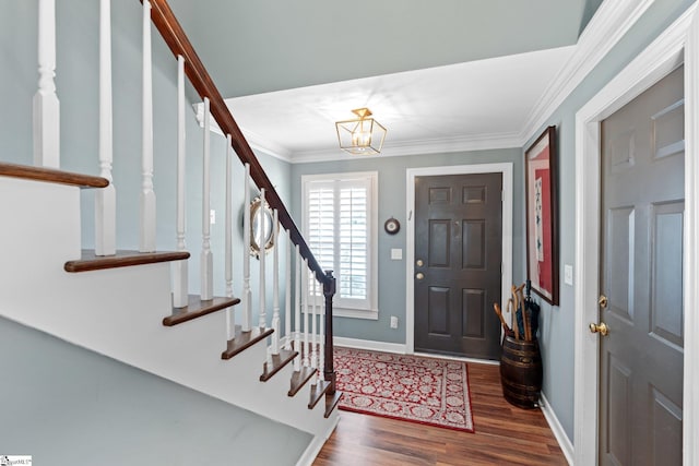 foyer entrance with ornamental molding and dark hardwood / wood-style flooring