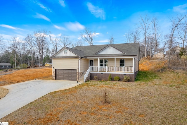 view of front of home with a garage, a front yard, and covered porch