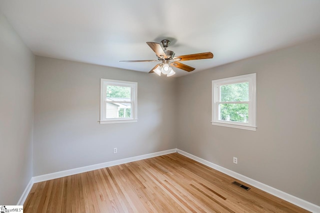 spare room featuring ceiling fan, a healthy amount of sunlight, and light hardwood / wood-style floors