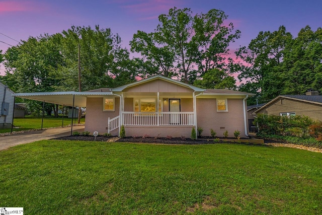 view of front of property featuring covered porch, an attached carport, a front lawn, and brick siding