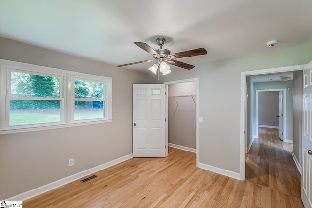 unfurnished bedroom with light hardwood / wood-style floors, a closet, and ceiling fan