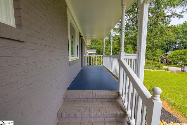 deck featuring covered porch and a lawn