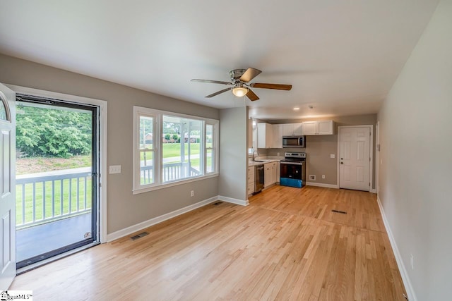 kitchen with visible vents, white cabinets, appliances with stainless steel finishes, light countertops, and a sink