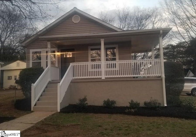 view of front of property with a porch and stairs