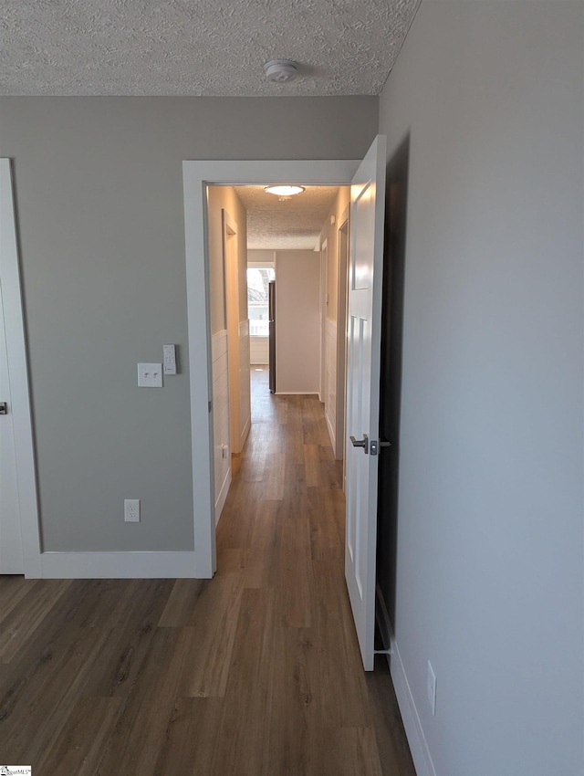 hall featuring hardwood / wood-style flooring and a textured ceiling