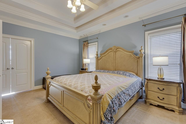 carpeted bedroom featuring crown molding, ceiling fan, and a tray ceiling