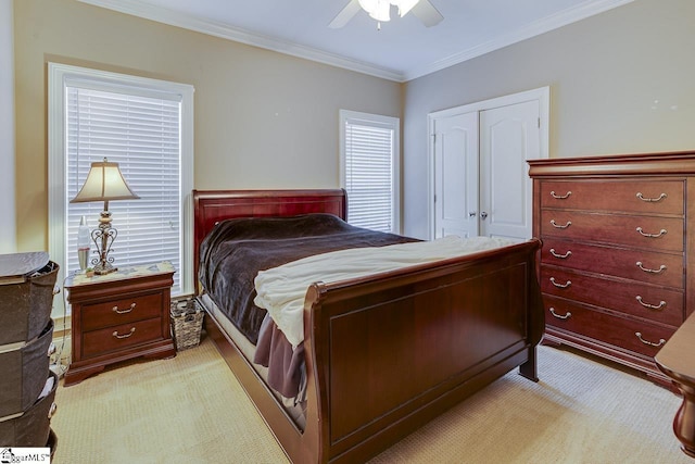 bedroom featuring crown molding, ceiling fan, a closet, and light carpet