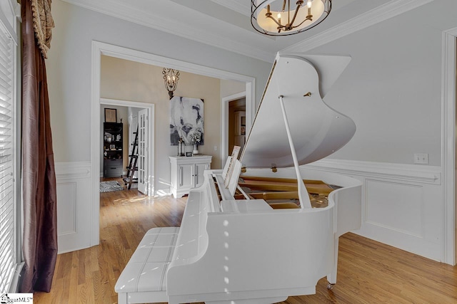 dining area with ornamental molding, a chandelier, and light hardwood / wood-style floors