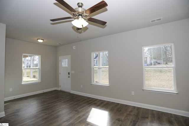 unfurnished room featuring dark wood-type flooring, ceiling fan, and plenty of natural light