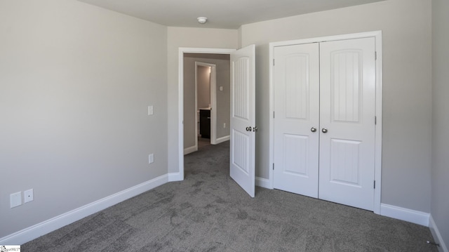 unfurnished bedroom featuring a closet and dark colored carpet