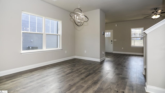 unfurnished dining area featuring dark hardwood / wood-style floors and ceiling fan with notable chandelier