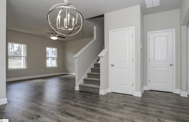 interior space with ceiling fan with notable chandelier and dark wood-type flooring