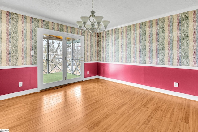 unfurnished room with hardwood / wood-style flooring, crown molding, a chandelier, and a textured ceiling