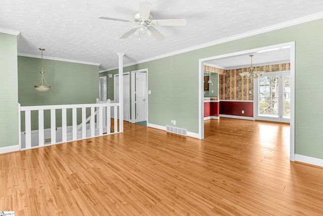 unfurnished room featuring hardwood / wood-style floors, ceiling fan with notable chandelier, ornamental molding, and a textured ceiling