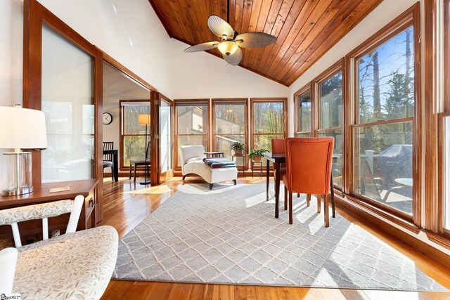 sunroom with lofted ceiling, wooden ceiling, and ceiling fan