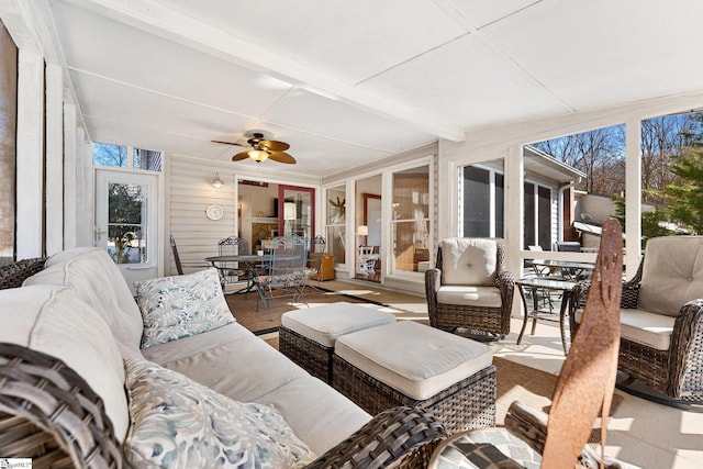 sunroom / solarium featuring ceiling fan, plenty of natural light, and beam ceiling