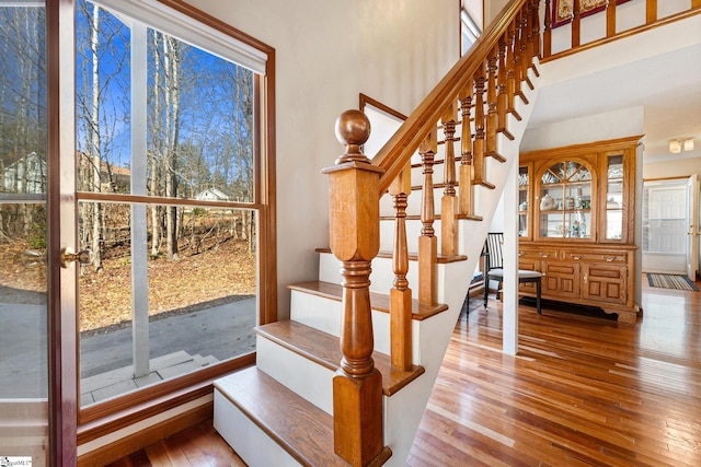 stairway featuring hardwood / wood-style flooring and a towering ceiling