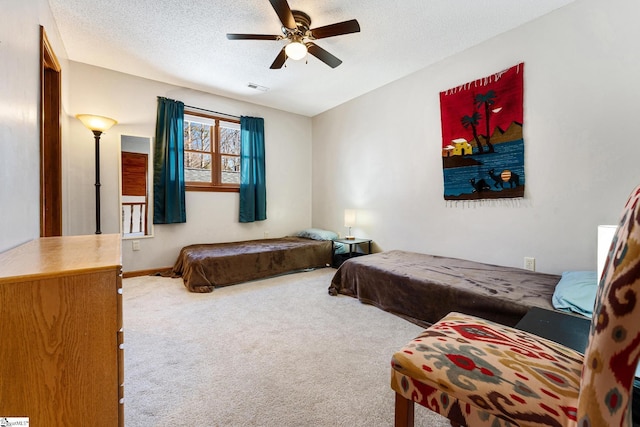 bedroom featuring ceiling fan, carpet, and a textured ceiling