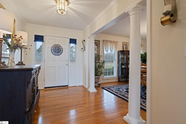 entrance foyer with a healthy amount of sunlight, decorative columns, and light wood-type flooring