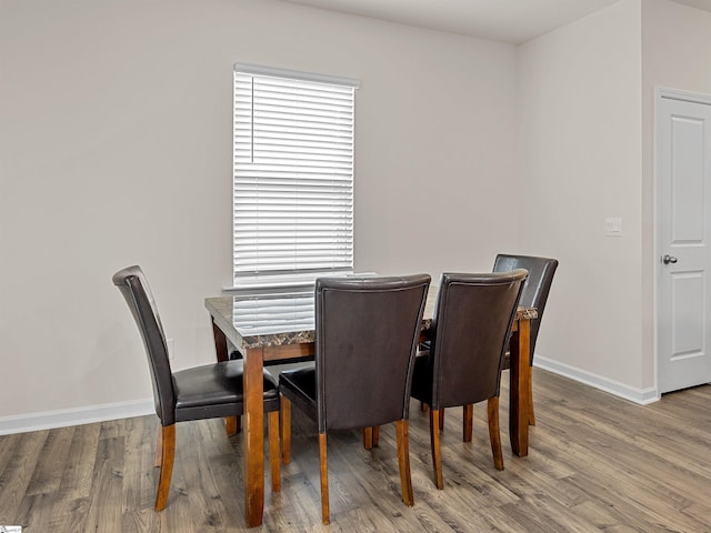 dining area featuring baseboards and wood finished floors