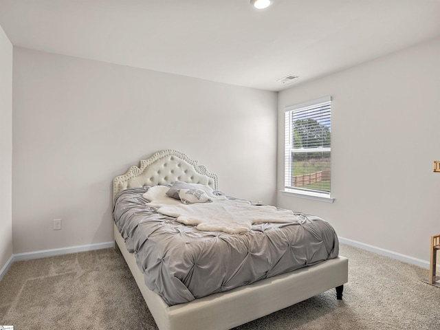 carpeted bedroom with visible vents and baseboards