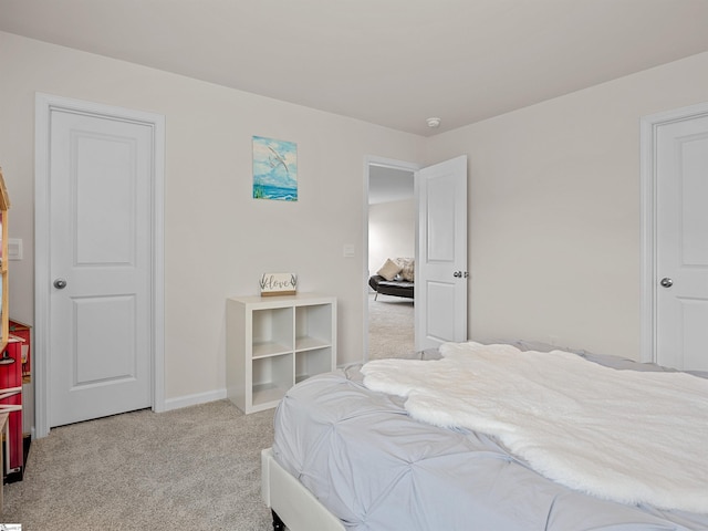 bedroom featuring light colored carpet and baseboards