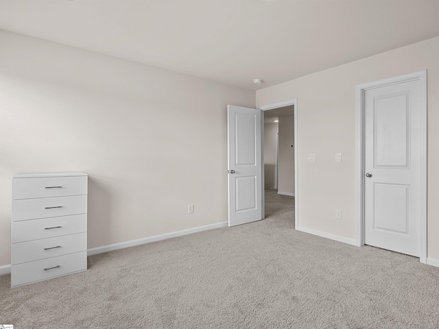 unfurnished bedroom featuring light carpet and baseboards