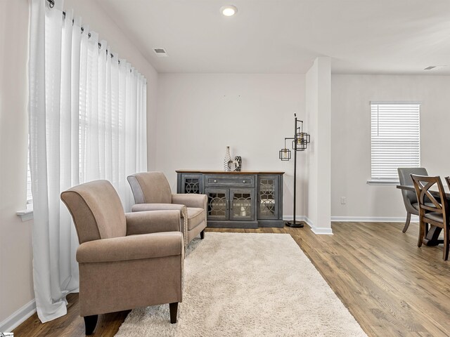 living area featuring recessed lighting, wood finished floors, visible vents, and baseboards