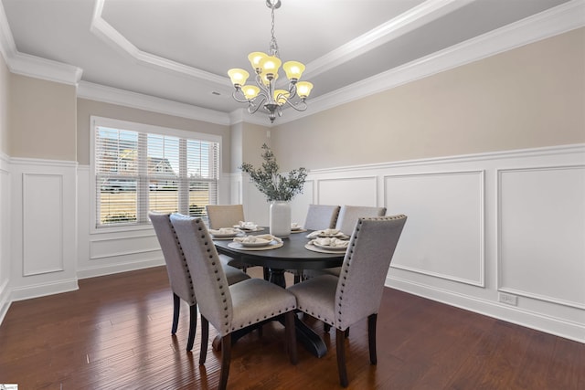 dining room with dark hardwood / wood-style floors, a tray ceiling, and a chandelier