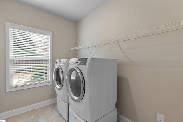 washroom with washer and dryer, a wealth of natural light, and light tile patterned floors