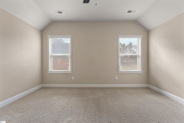 empty room with lofted ceiling, carpet floors, and ceiling fan