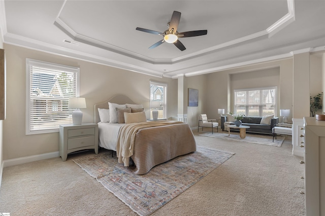 bedroom featuring crown molding, light colored carpet, a tray ceiling, and multiple windows