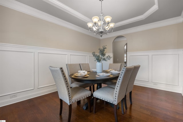 dining area with dark hardwood / wood-style flooring, a notable chandelier, and a raised ceiling