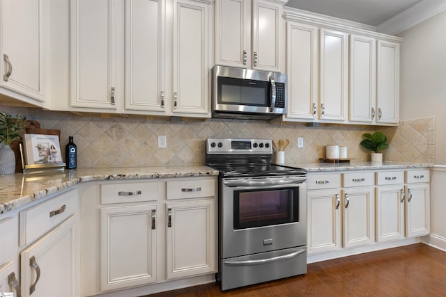 kitchen with dark wood-type flooring, white cabinetry, stainless steel appliances, light stone countertops, and decorative backsplash