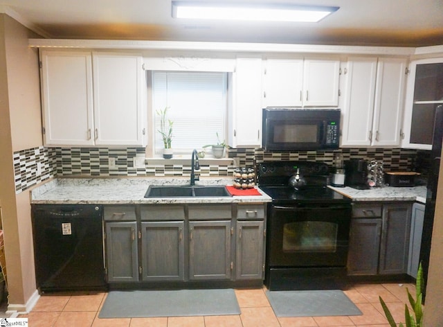 kitchen with tasteful backsplash, white cabinetry, sink, and black appliances