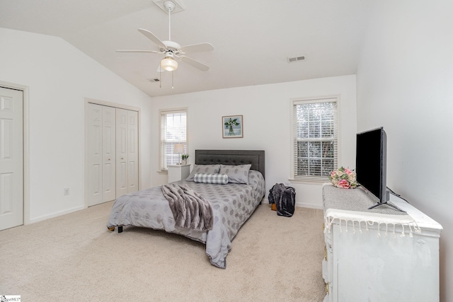 bedroom with multiple closets, lofted ceiling, carpet flooring, and ceiling fan