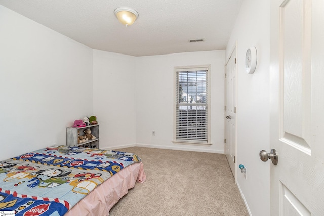 carpeted bedroom featuring a textured ceiling