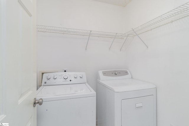 clothes washing area with washing machine and dryer