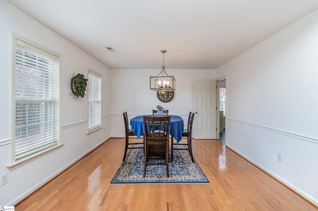 dining room with hardwood / wood-style flooring and an inviting chandelier