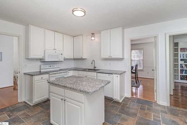 kitchen with a kitchen island, sink, white cabinets, decorative backsplash, and white appliances