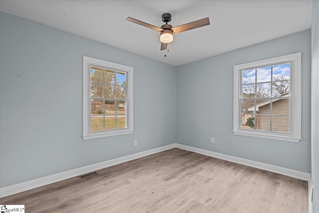 empty room with ceiling fan, plenty of natural light, and light hardwood / wood-style floors