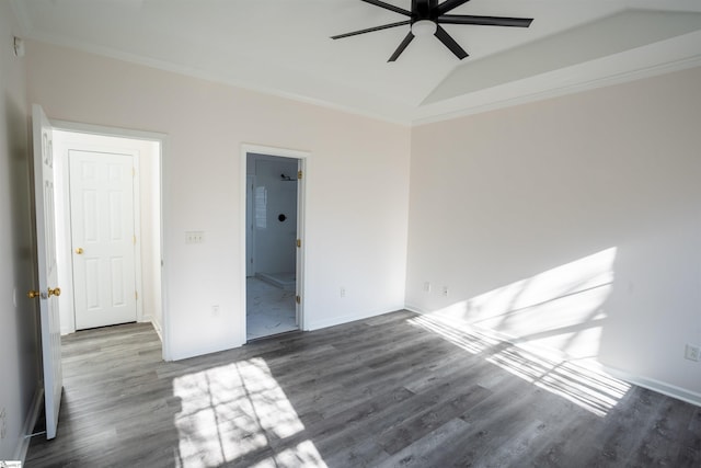 empty room featuring dark wood-type flooring, lofted ceiling, and crown molding