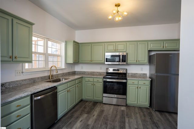 kitchen featuring sink, dark wood-type flooring, appliances with stainless steel finishes, light stone countertops, and green cabinetry