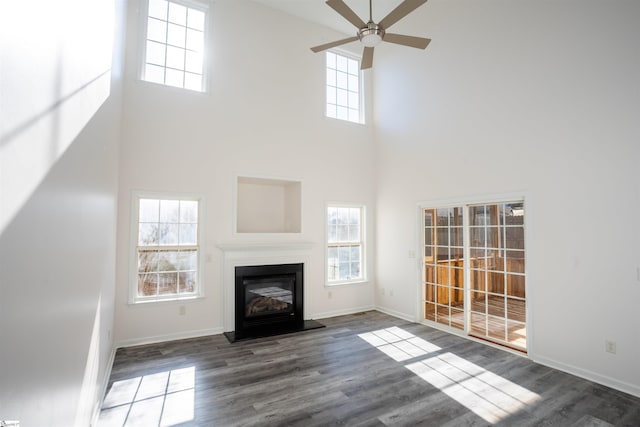 unfurnished living room with dark hardwood / wood-style floors and ceiling fan