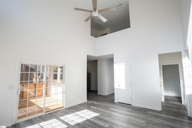 unfurnished room with hardwood / wood-style flooring, ceiling fan, and a towering ceiling